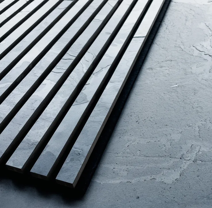 Akurock Akustikpaneel von stonearts® mit moderner Lamellenstruktur, das auf dem originalen Steinblock liegt, von dem die Oberflächenbeschichtung im Werk abgezogen wurde.