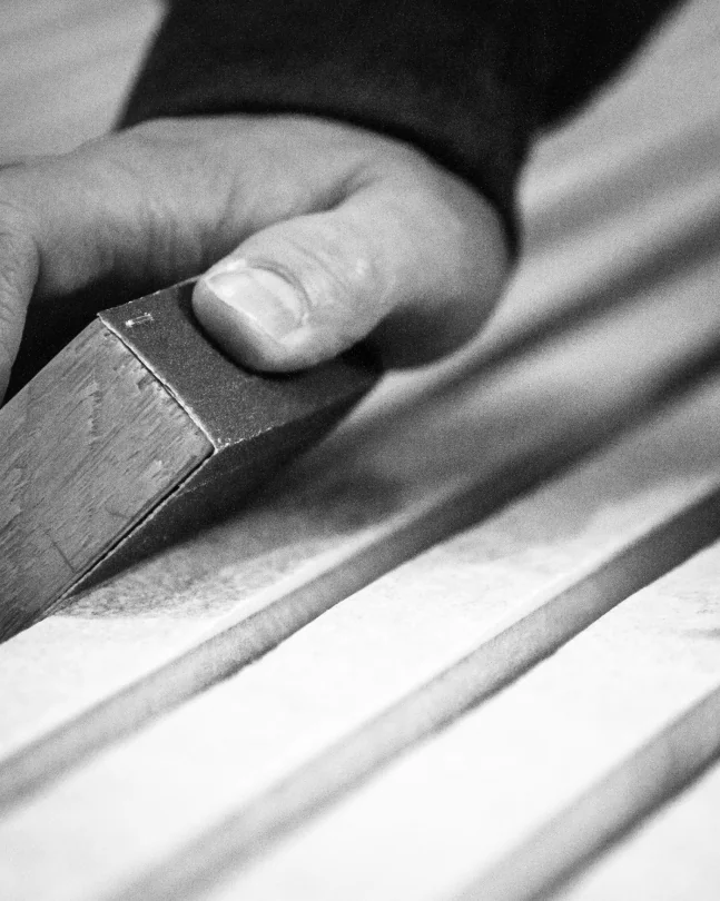 Handwerkliche Bearbeitung eines Akurock Akustikpaneels, zeigt die Präzision und Qualität, die in die Herstellung der stonearts® Akustikpaneele einfließt.