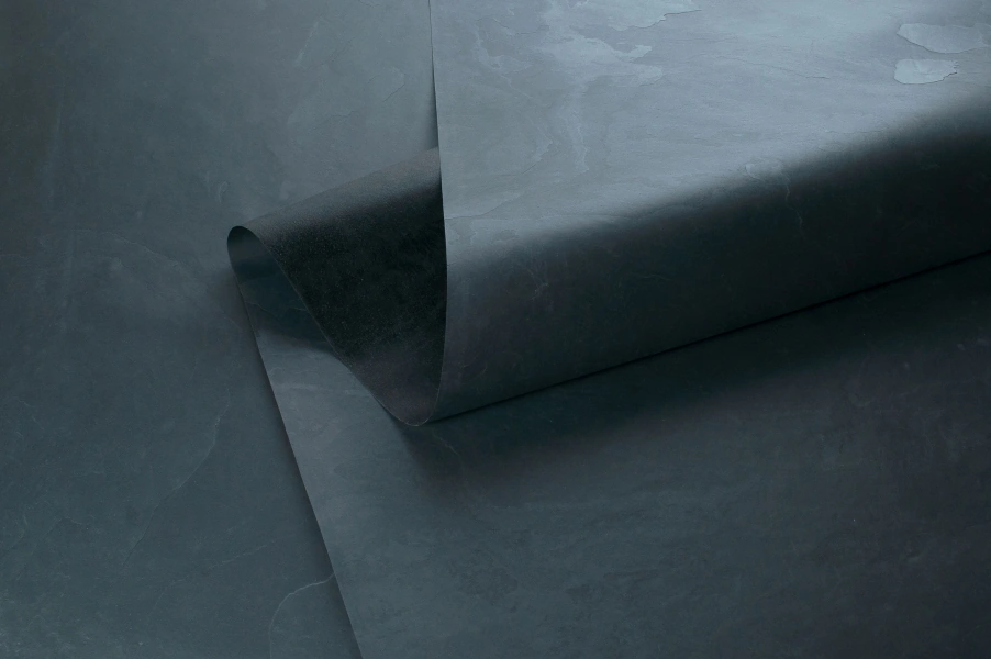 Stoneskin aus schwarzem Schiefer, hauchdünn und flexibel, zeigt die feine Struktur von Millionen Jahren geologischer Prozesse, der für die vereedelung von stonearts® Akustikpaneelen verwendet wird.